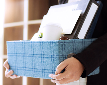 Woman holding box filled with office items