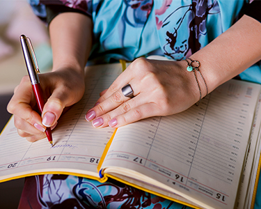 woman scheduling in a planner