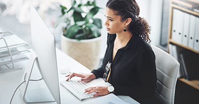 Woman sitting at her desk in front of a computer