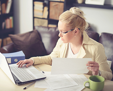 Women working on a computer while holding paper