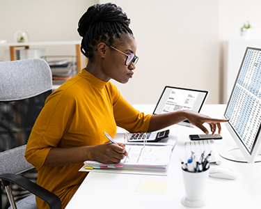 Woman looking at spreadsheets on a computer screen