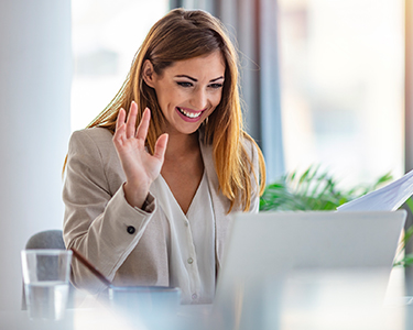 Woman waving at her computer